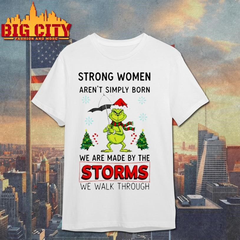 Grinch Santa hat strong women aren’t simply born we are made by the storms we walk through Merry Christmas shirt